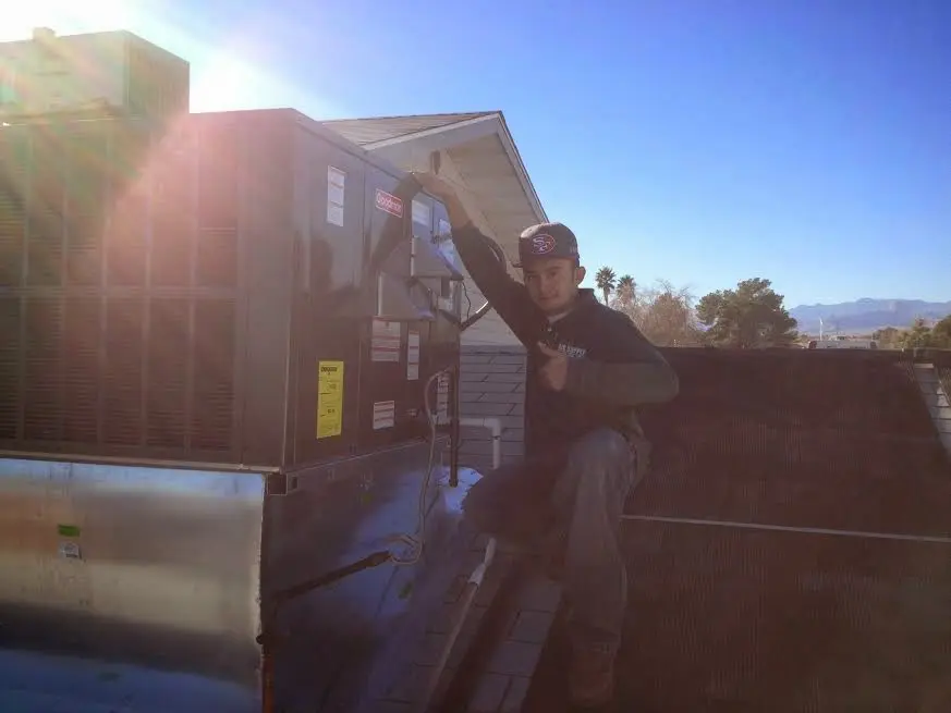 HVAC technician performing HVAC Inspection on a rooftop unit in Moreau